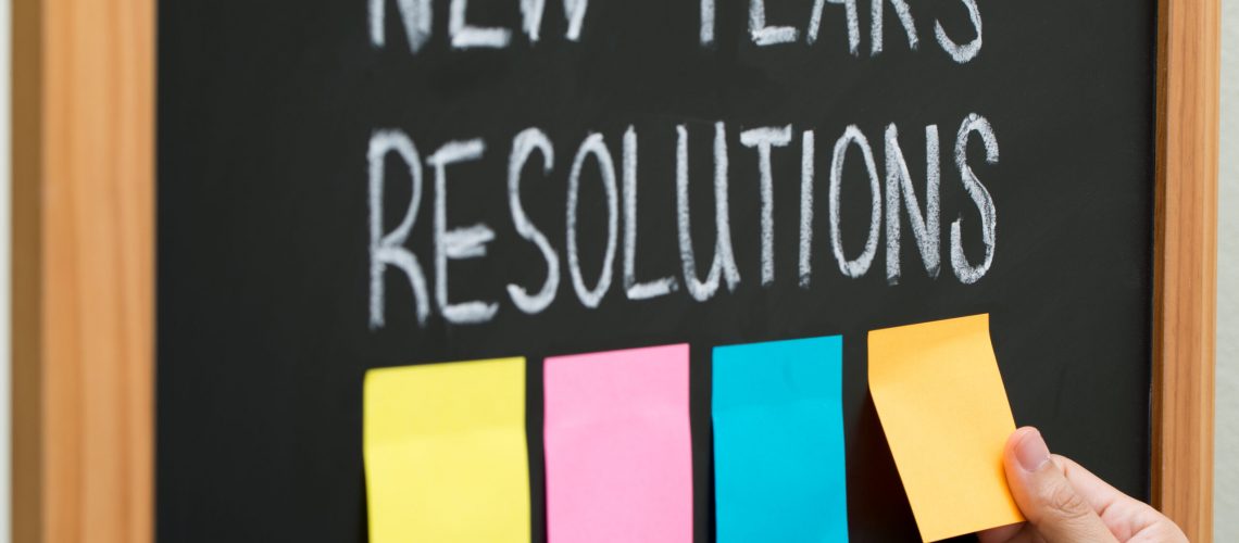 New year resolutions or goals with sticky notes on blackboard